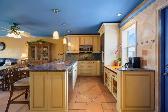 a kitchen with stainless steel appliances granite countertop a stove a sink dishwasher and a refrigerator