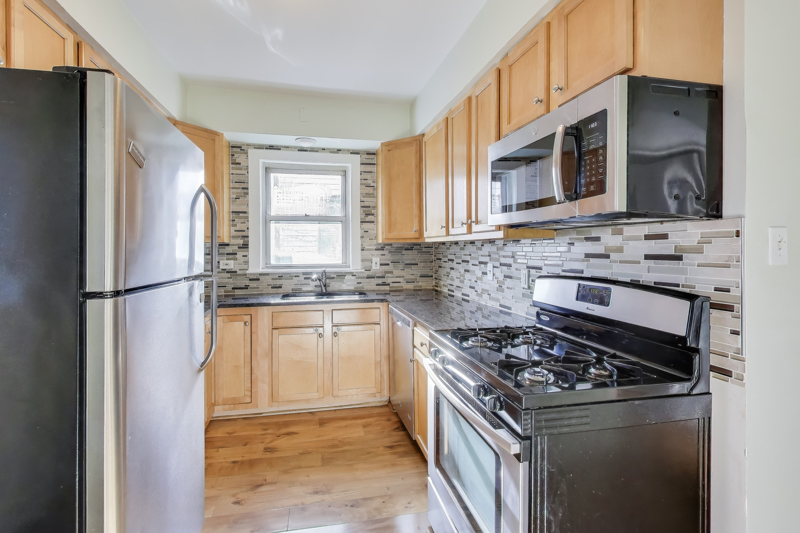 620 Elgin Avenue, Unit 2 Forest Park, IL 60130 - Photo 3 of 25 a kitchen with stainless steel appliances granite countertop a stove a sink and a refrigerator