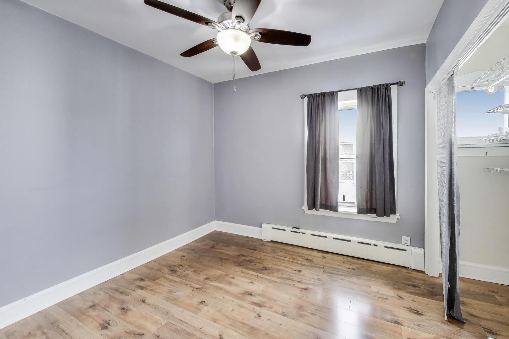 620 Elgin Avenue, Unit 2 Forest Park, IL 60130 - Photo 8 of 25 a view of an empty room with wooden floor and a window