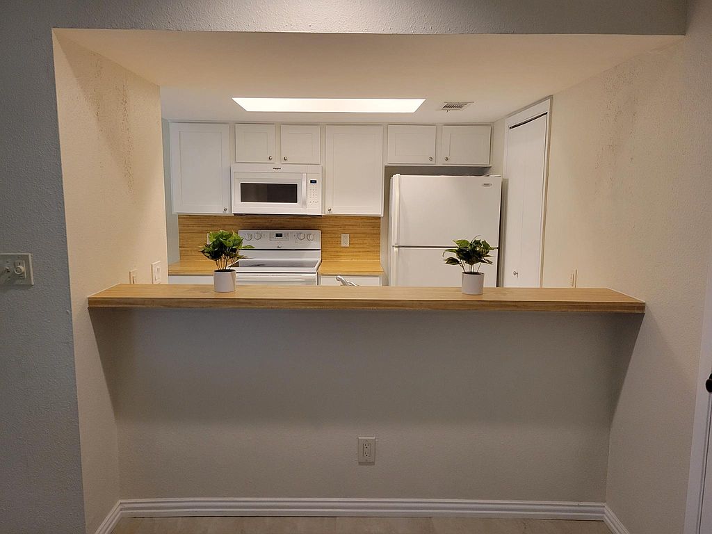 1401 Camp Craft Road, Unit C Austin, TX 78746 - Photo 2 of 12 An inviting pass-through window connects this well-appointed kitchen to adjacent living spaces.