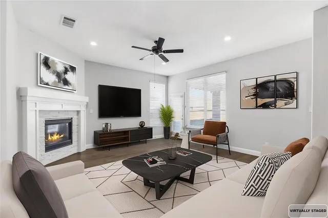 a living room with furniture a flat screen tv and a fireplace