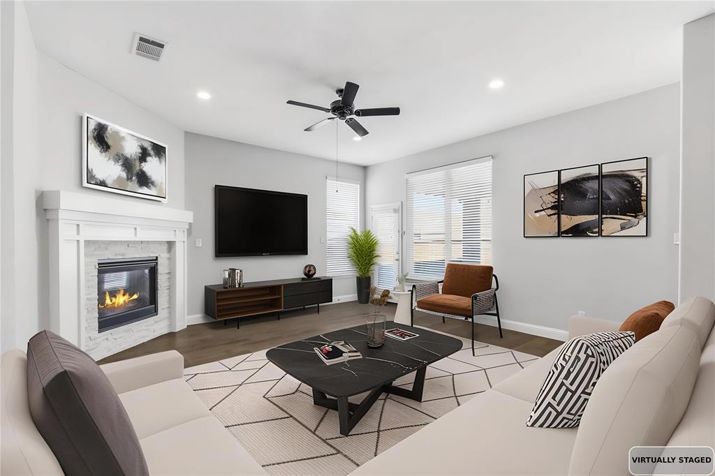 a living room with furniture a flat screen tv and a fireplace