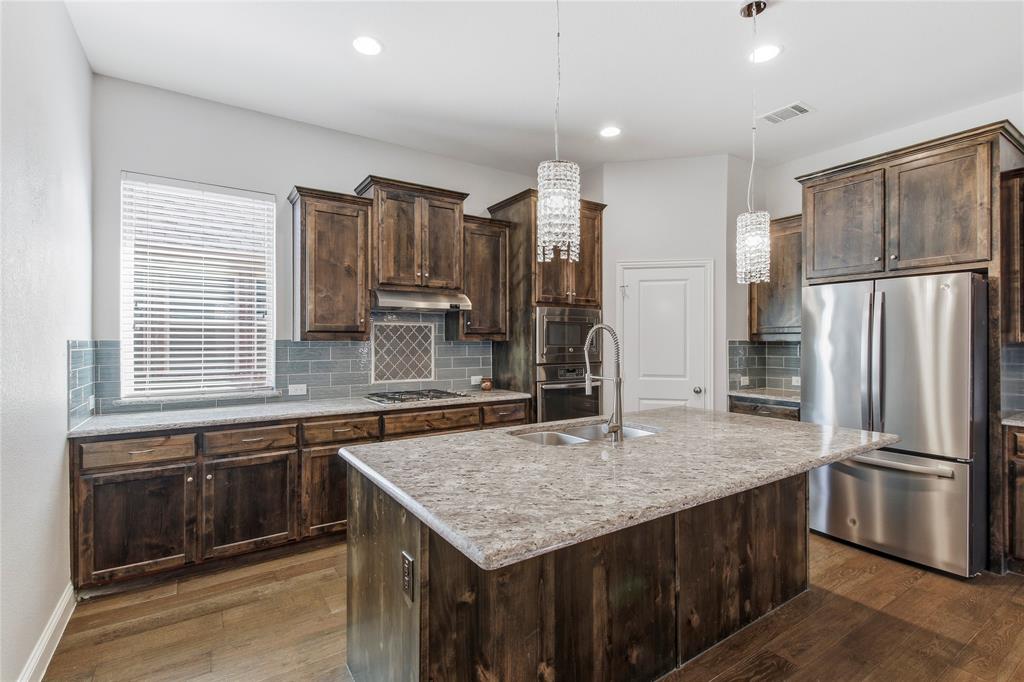 413 Allbright Road Celina, TX 75009 - Photo 12 of 37 a kitchen with stainless steel appliances granite countertop a refrigerator a sink and a stove