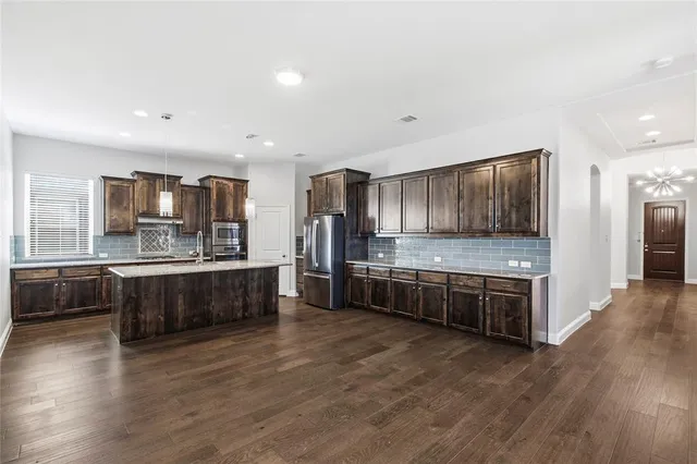 a large kitchen with stainless steel appliances and a large counter top