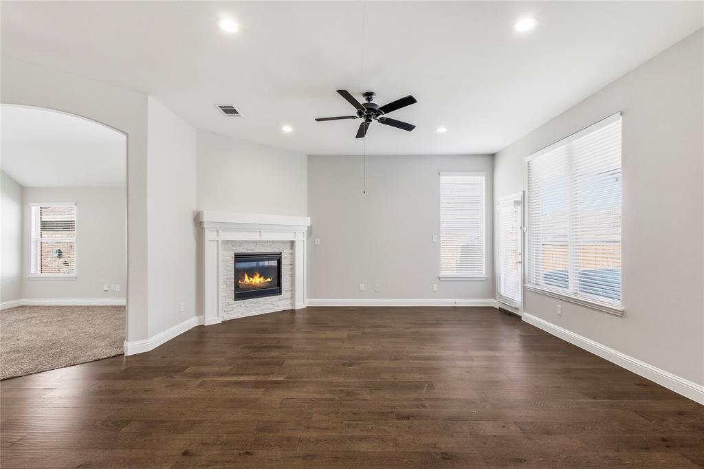 413 Allbright Road Celina, TX 75009 - Photo 2 of 37 an empty room with wooden floor fireplace and windows
