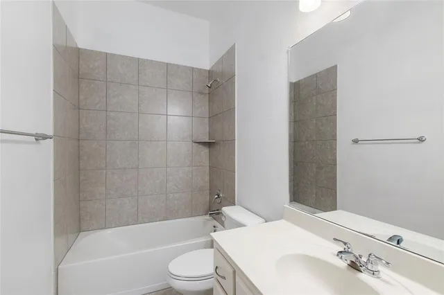a bathroom with a bathtub shower sink vanity and toilet