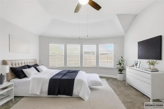 a spacious bedroom with a bed and a flat screen tv