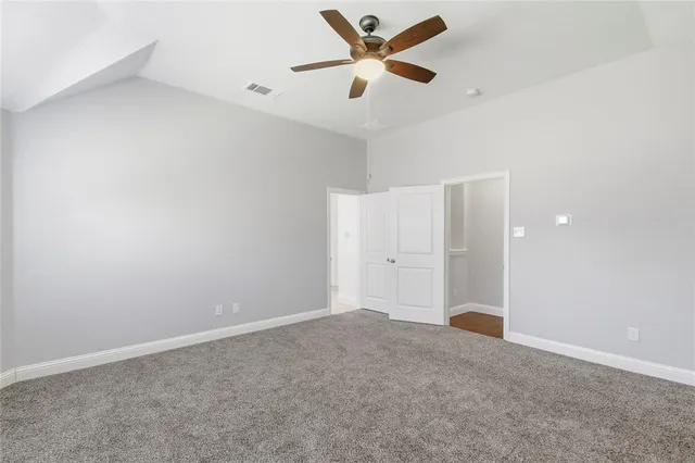 an empty room with closet and fan