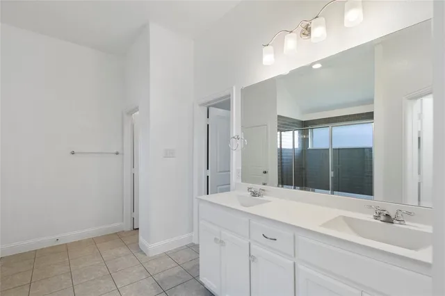 a bathroom with a double vanity sink and a mirror