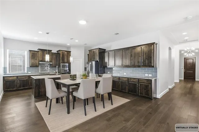 a large kitchen with a table and chairs