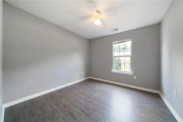 a view of an empty room and chandelier fan