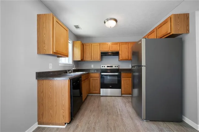 a kitchen with stainless steel appliances a refrigerator and a stove