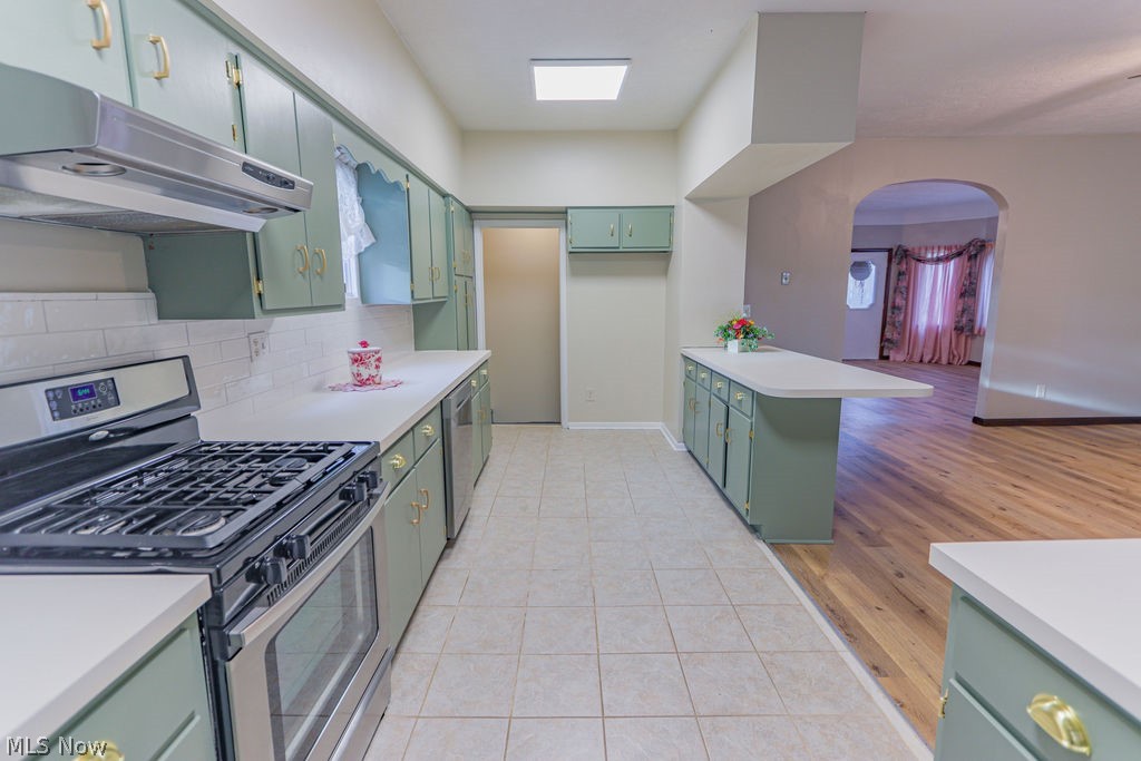51883 Telegraph Road Amherst, OH 44001 - Photo 24 of 49 Kitchen featuring tasteful backsplash, light wood-type flooring, appliances with stainless steel finishes, and green cabinets