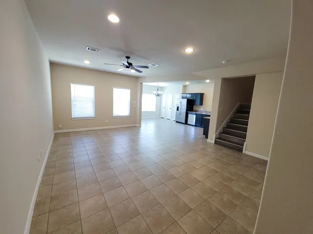 an empty room with chandelier and windows