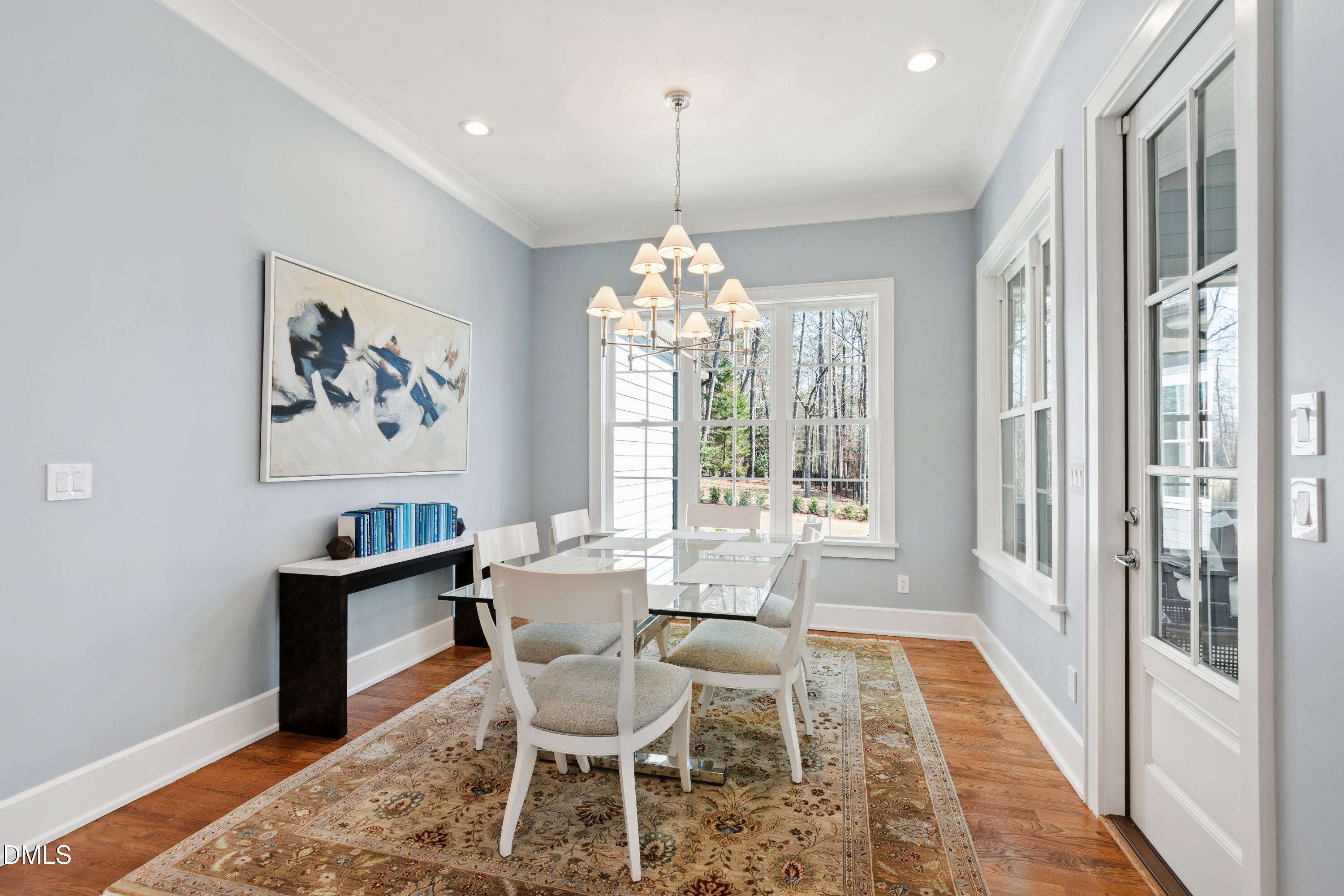 2721 Sanctuary Woods Lane Raleigh, NC 27606 - Photo 13 of 50 a dining room with wooden floor a chandelier a wooden table and chairs