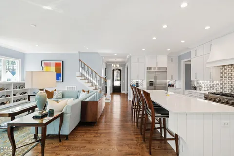 a living room with furniture a table and kitchen view