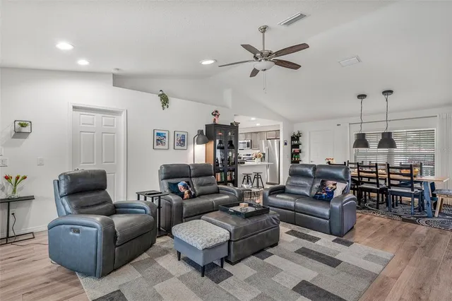 a living room with furniture kitchen view and a window