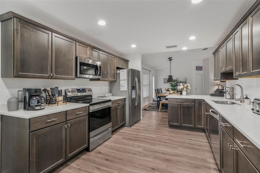 276 North Cunningham Avenue Inverness, FL 34453 - Photo 23 of 48 a kitchen with stainless steel appliances granite countertop wooden cabinets a sink dishwasher a stove and a refrigerator