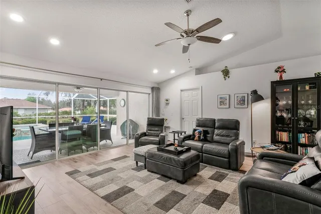 a living room with furniture ceiling fan and a large window
