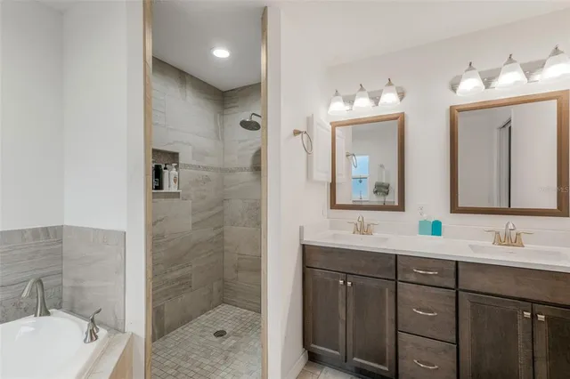 a bathroom with a double vanity sink mirror and shower