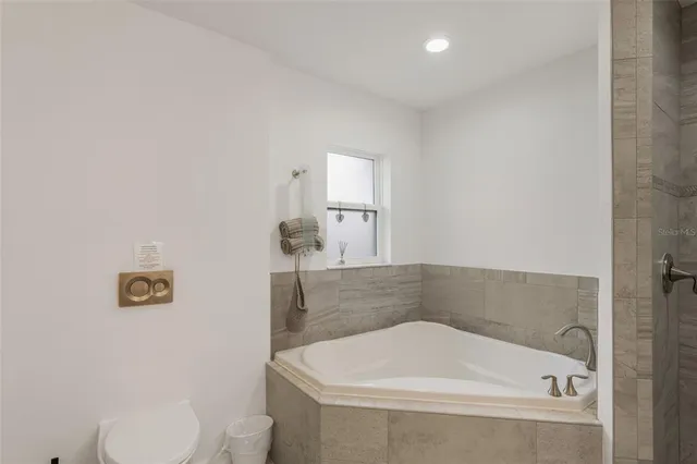 a bathroom with a tub and toilet