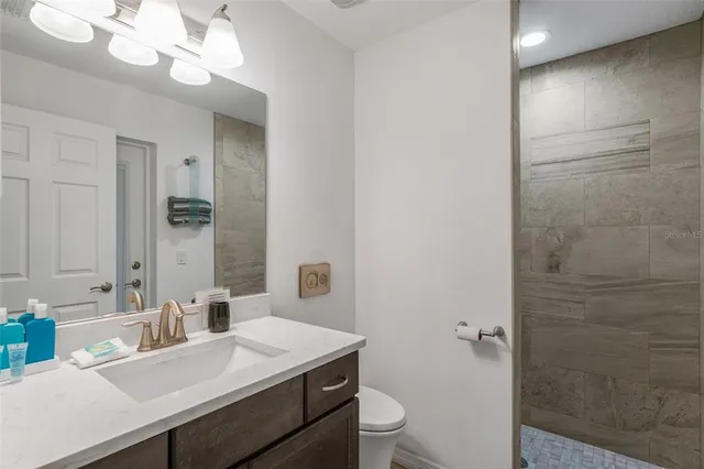 a bathroom with a sink a toilet and a mirror