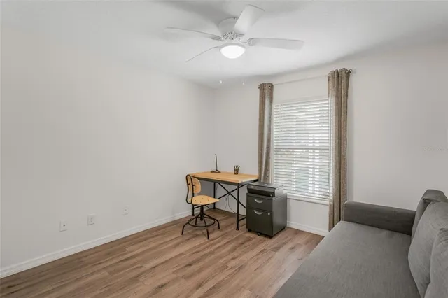 a view of a workspace with furniture and a window