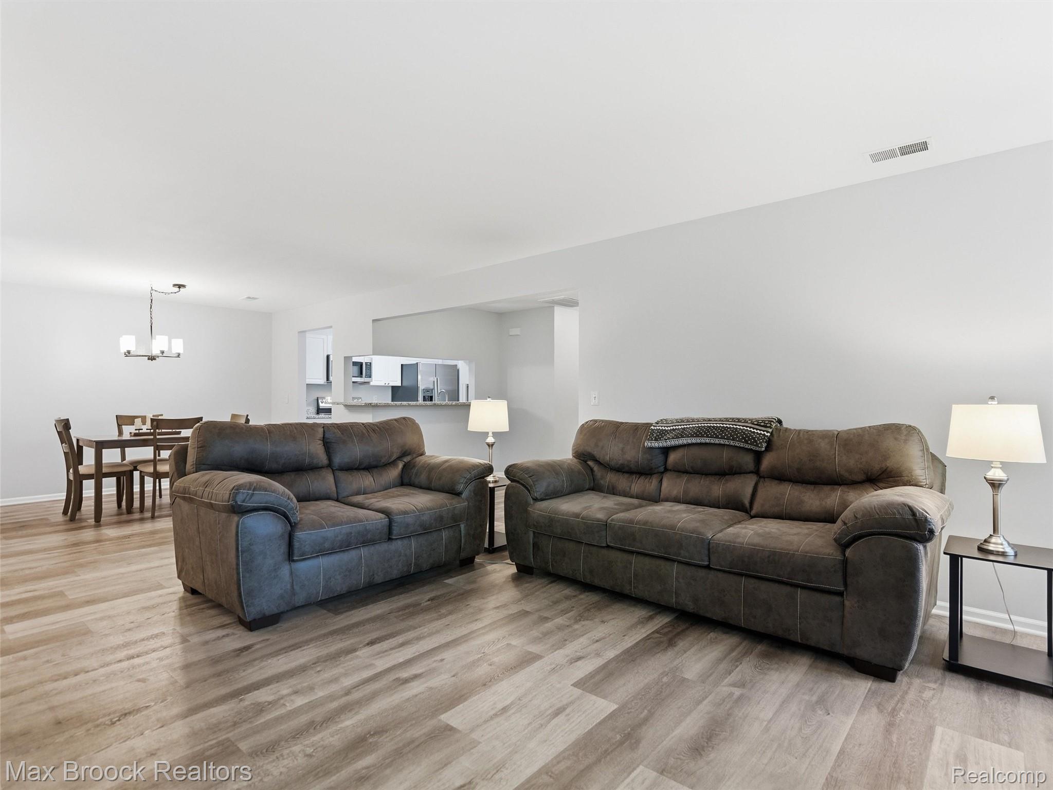 3562 Tremonte Circle Rochester, MI 48306 - Photo 10 of 33 Spacious open-concept living area featuring wood-finish flooring, neutral wall tones, and recessed lighting