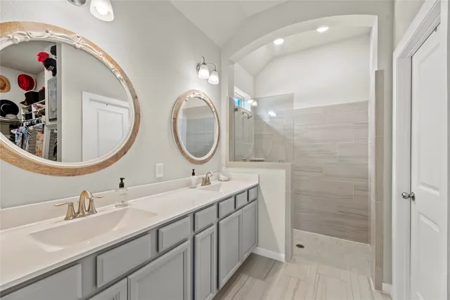 a bathroom with a double vanity sink mirror and shower