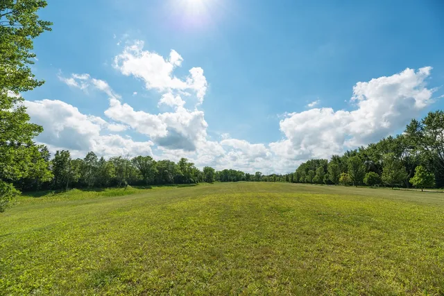a view of a big yard with a house in the background