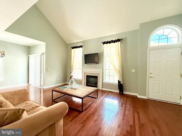 a living room with fireplace furniture and a wooden floor