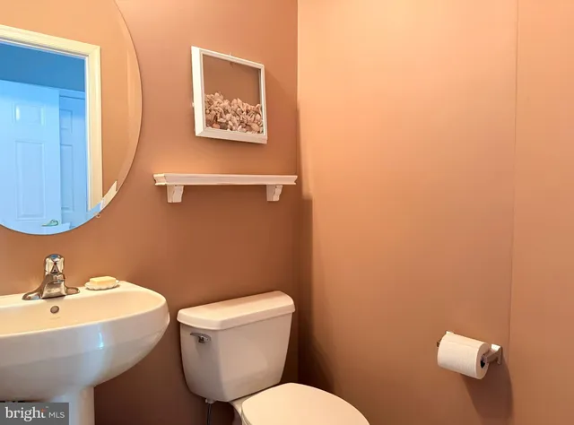a bathroom with a toilet a sink and mirror