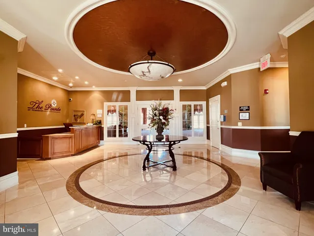 a lobby with a chandelier furniture and a large window