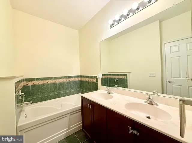 a bathroom with a tub sink and mirror