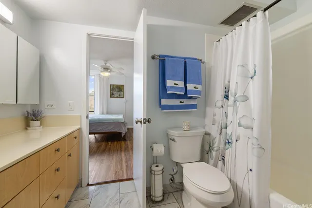 a bathroom with a granite countertop sink toilet and shower