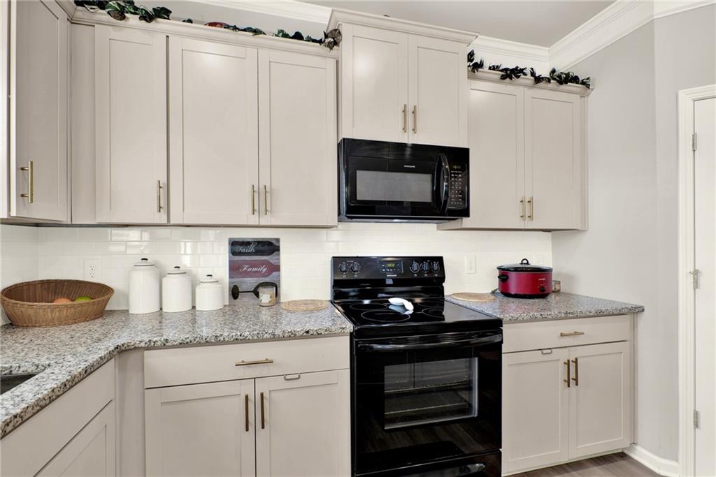 25 Thacker Trail Adairsville, GA 30103 - Photo 16 of 47 a kitchen with granite countertop a sink stove and microwave