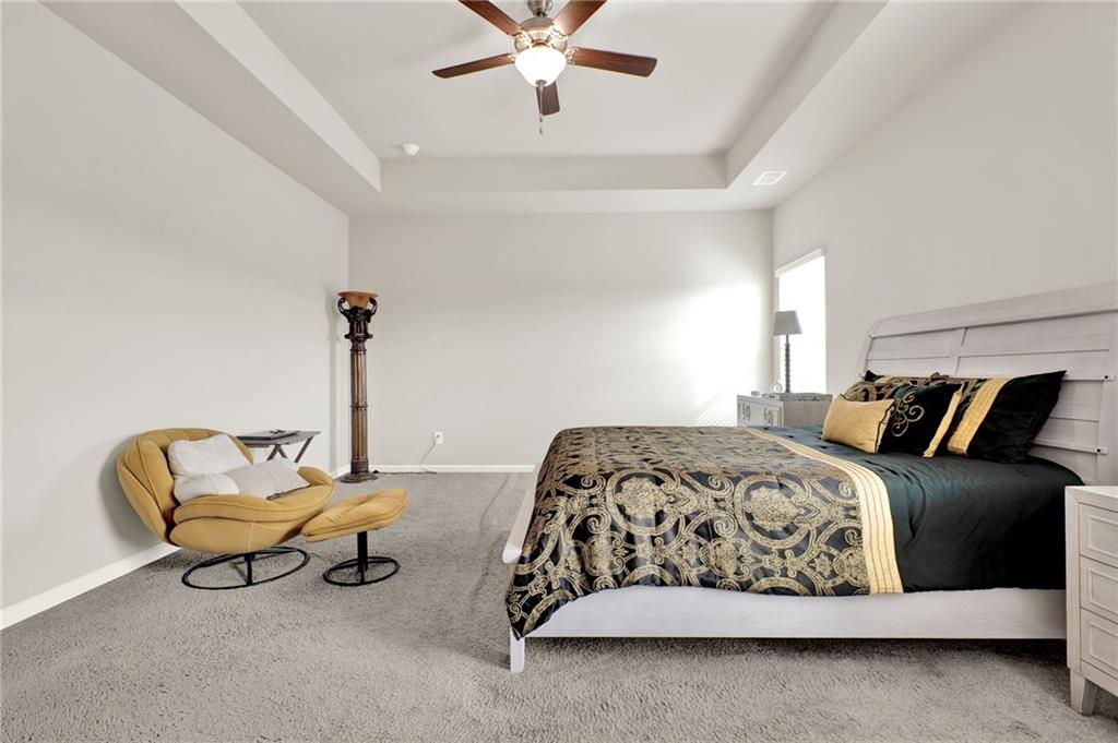 25 Thacker Trail Adairsville, GA 30103 - Photo 27 of 47 a spacious bedroom with a bed and a chandelier