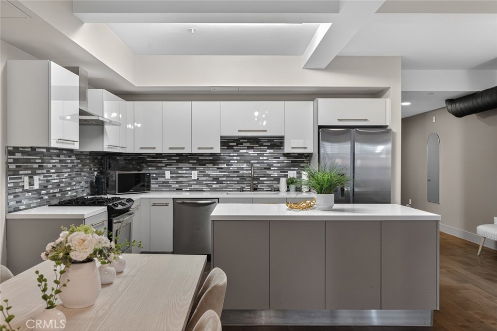 433 Pine Avenue, Unit 102 Long Beach, CA 90802 - Photo 16 of 60 a kitchen with stainless steel appliances kitchen island granite countertop a sink and cabinets