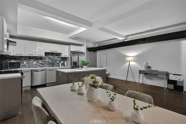 a kitchen with stainless steel appliances kitchen island granite countertop a sink a refrigerator and cabinets