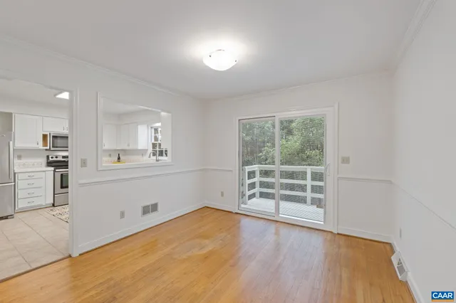 a view of a kitchen with wooden floor and a window