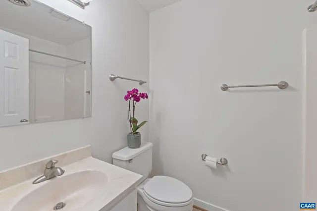 a bathroom with a sink mirror vanity and toilet