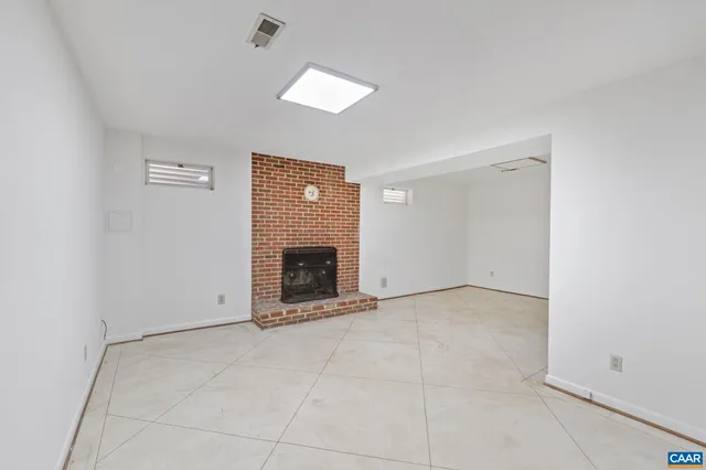 a view of an empty room with a fireplace and a window