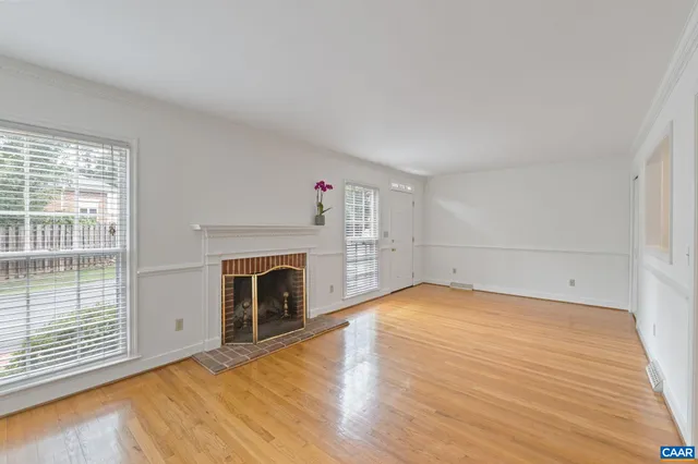 a view of empty room with wooden floor and fireplace
