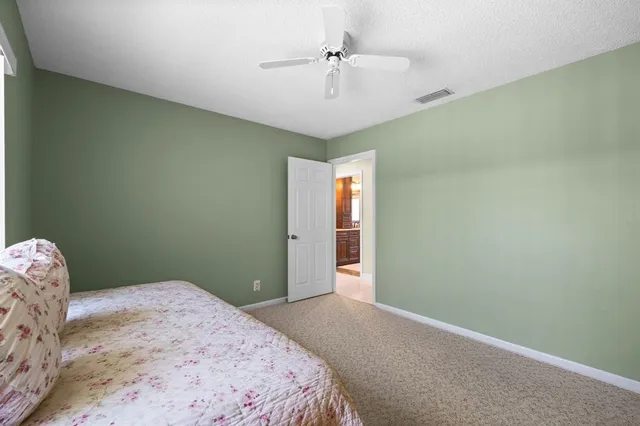 a bedroom with a bed and a chandelier fan