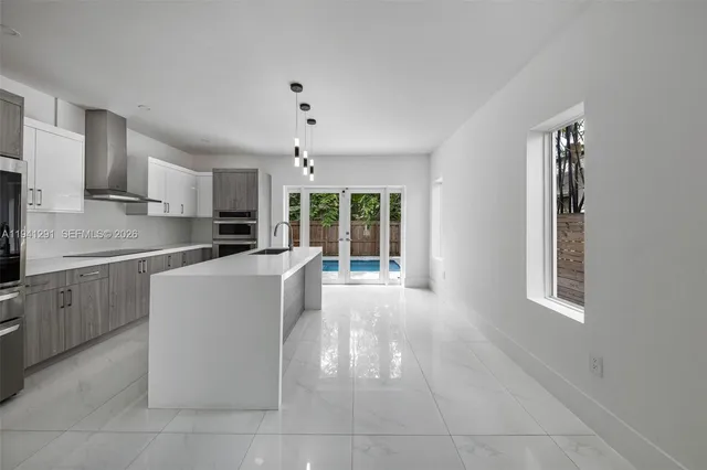 a kitchen with kitchen island stainless steel appliances a stove a table and chairs