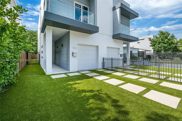 a view of a house with a backyard and a patio