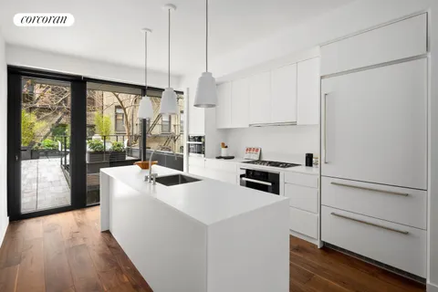 a kitchen with a stove a refrigerator and a view of living room