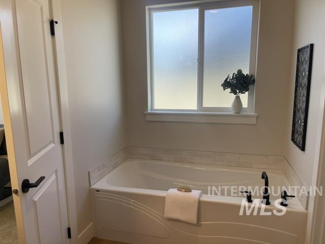 2035 Sumac Avenue Middleton, ID 83644 - Photo 8 of 17 Soaking tub featuring matte black fixtures, an accent tile surround, and a privacy window
