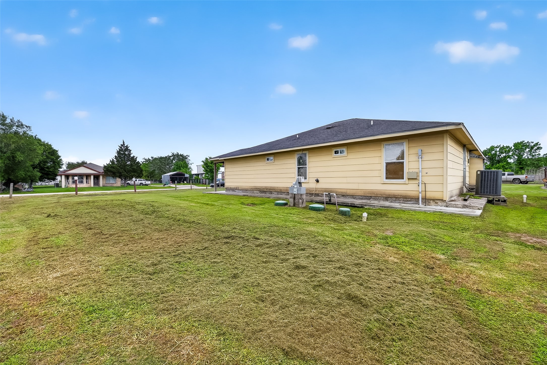6014 Linda Drive Rosharon, TX 77583 - Photo 4 of 22 The back exterior displays a practical layout with easy access to utility fixtures and the level backyard space.