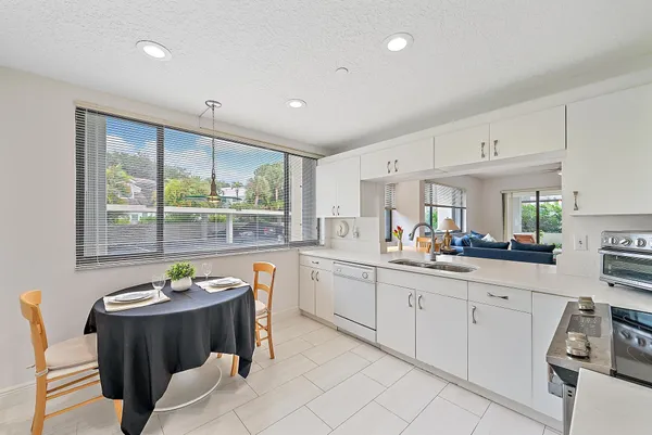 a large white kitchen with a large window